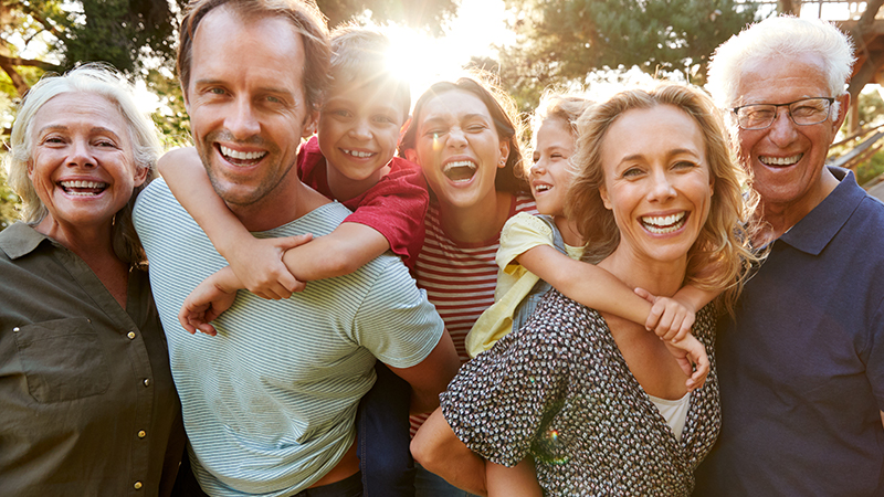 Diverse Personengruppe mit mehreren Generationen, lachend.